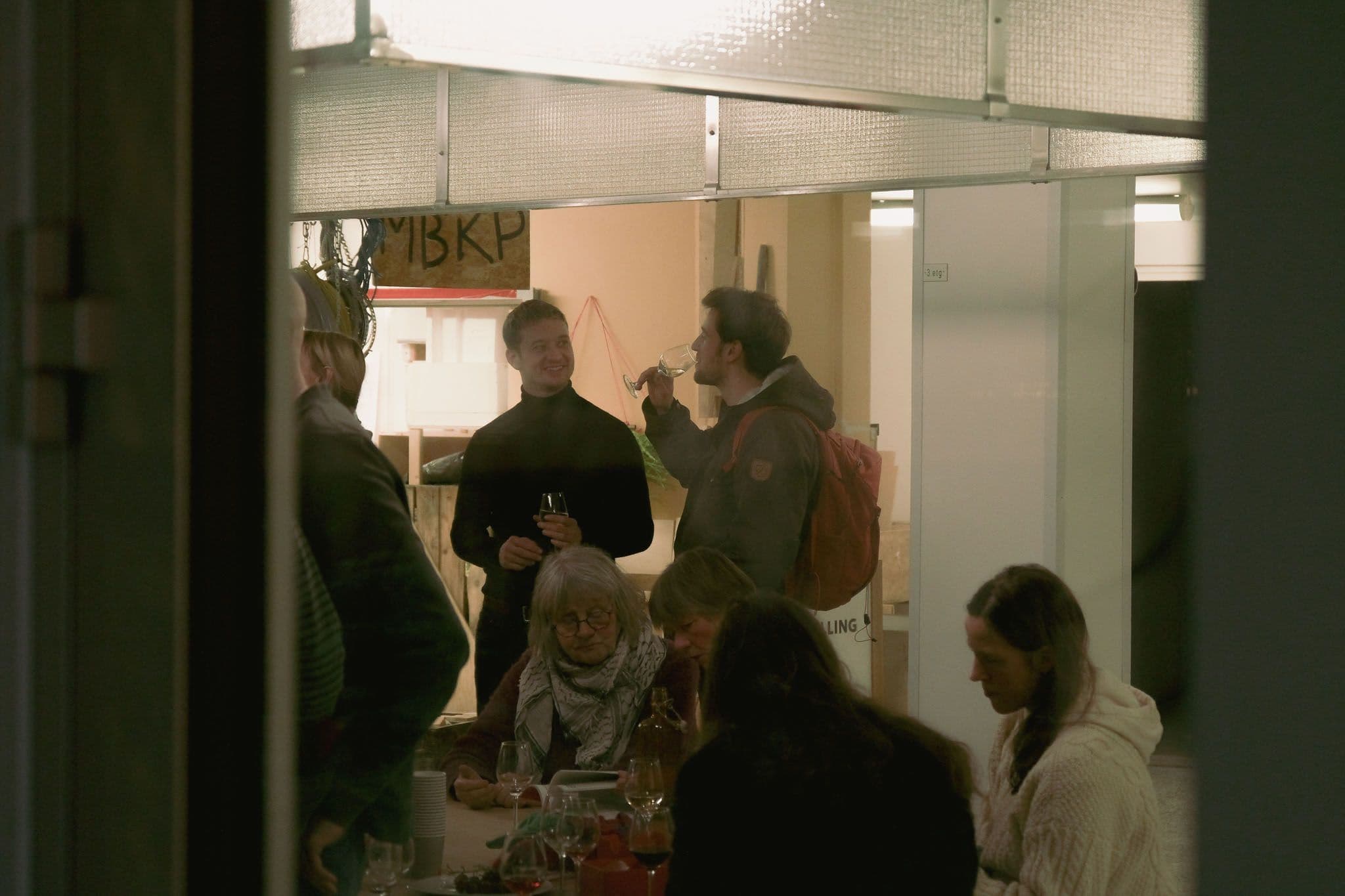 People standing talking with drinks.